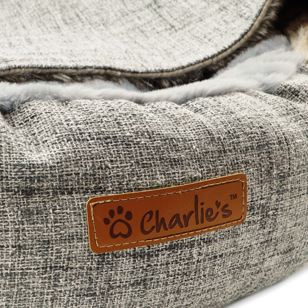 Close-up of the soft and fluffy material and Charlie's Pet logo on the Charlie's Snookie Hooded Pet Bed.