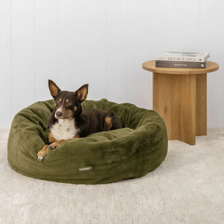  A peaceful dog curled up in the Leaf-colored Snooza Luxe Fur Cuddler, demonstrating the bed's ultimate comfort.