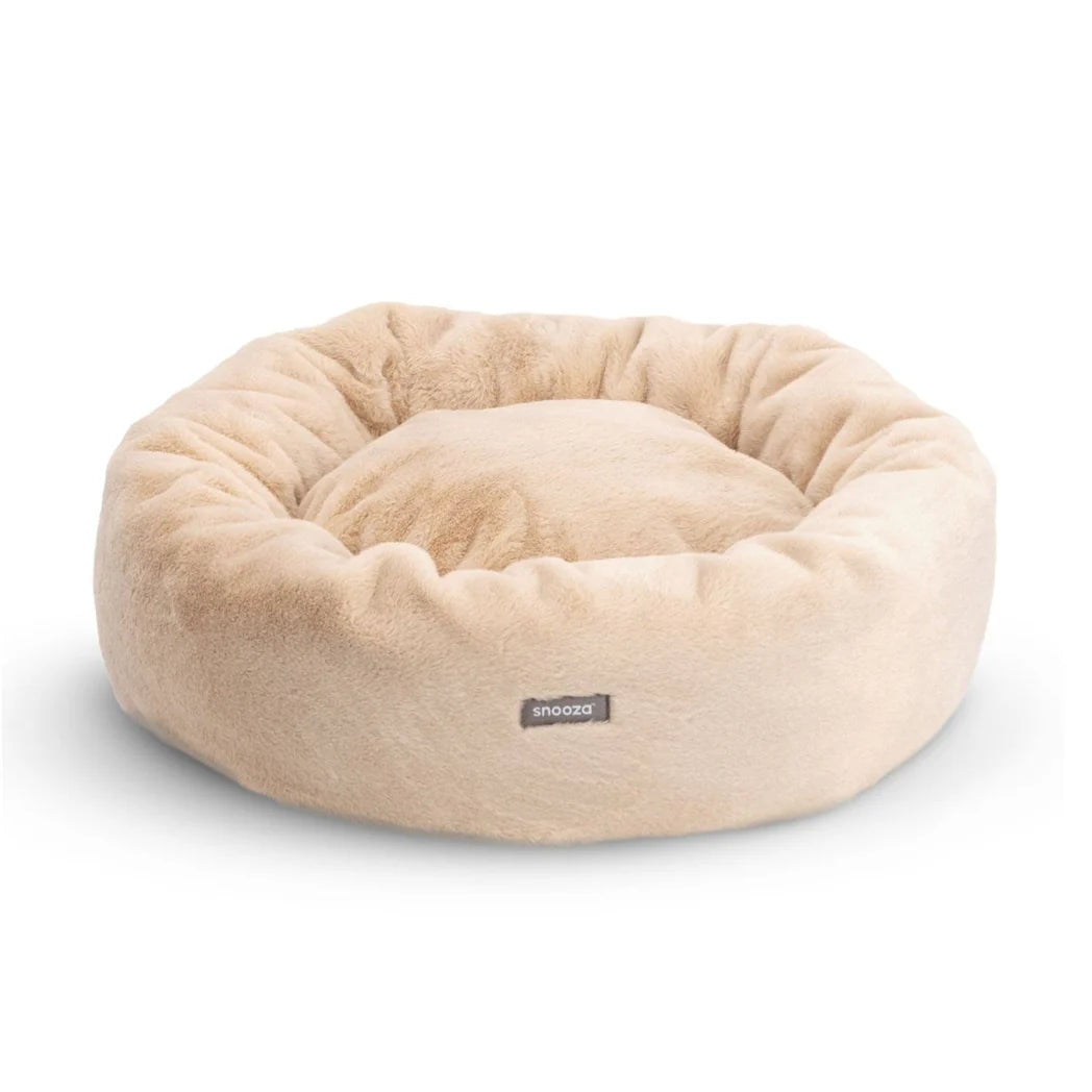 Frontal view of the Oat Snooza Luxe Fur Cuddler, showcasing the Snooza logo and the bed's inviting donut shape.