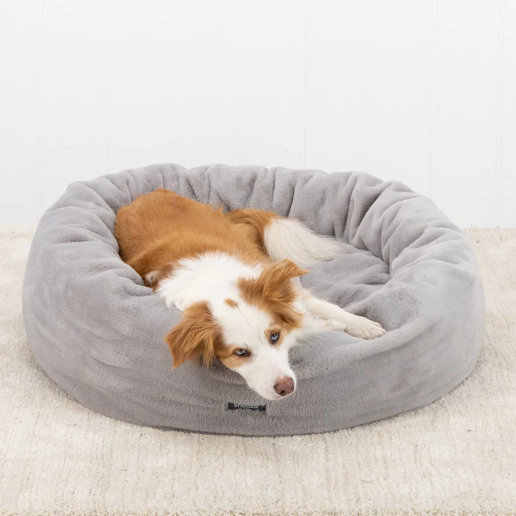 A happy dog nestled in the Twilight-colored Snooza Luxe Fur Cuddler, demonstrating the bed's inviting warmth.