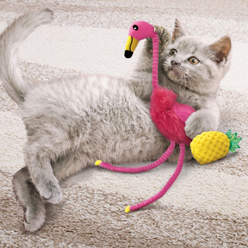 A cat engaging with the KONG flamingo toy, dragging it by its long, crinkly legs.