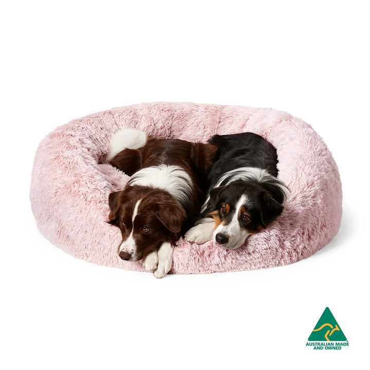 Dogs in Snooza Calming Cuddler Bliss Pink Pet Bed on white background with Australian made symbol.