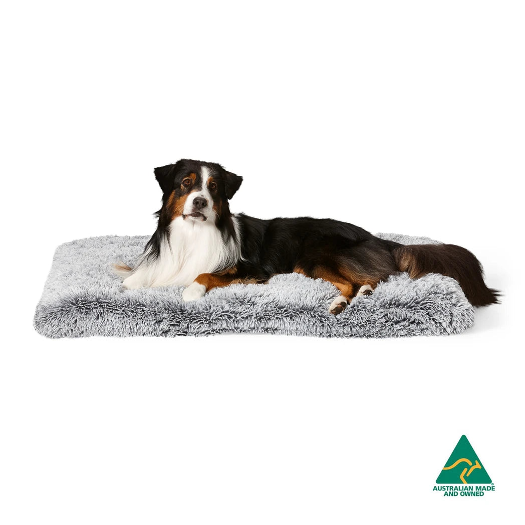 Snooza Calming Multimat - Silver Fox on Floor: Versatile pet mat used as a floor mat, showcasing its luxurious faux fur texture with a relaxed dog on top.