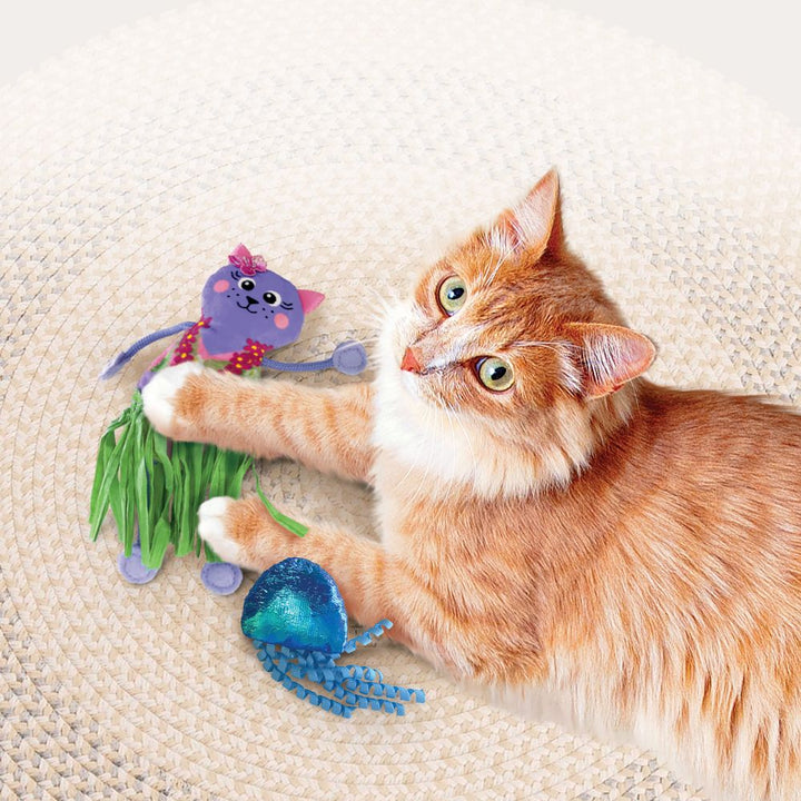 A cat batting at the KONG jellyfish toy with curly tentacles.