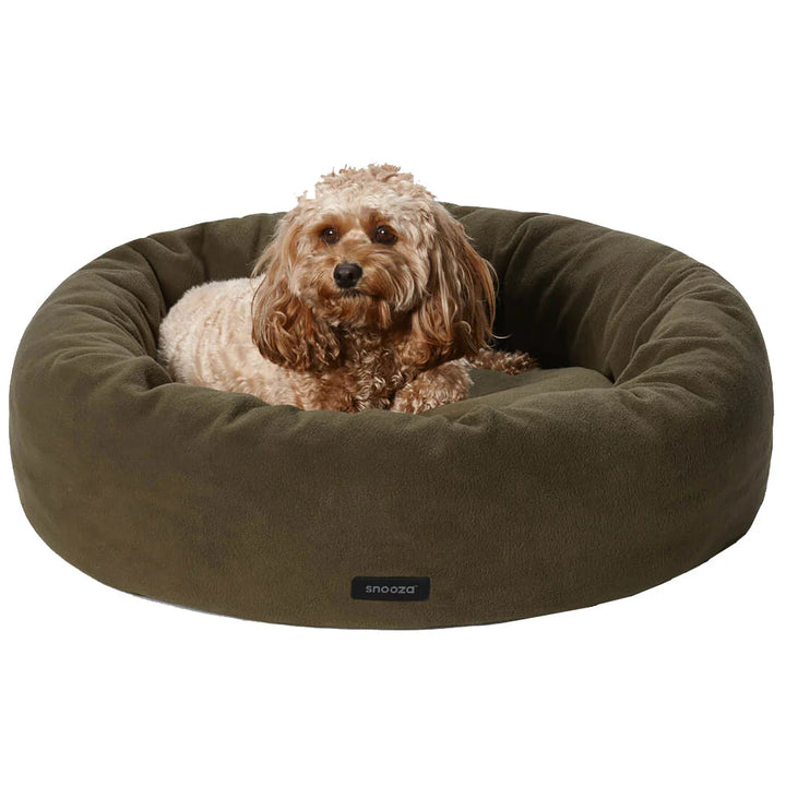 Fluffy dog resting comfortably in the Snooza Self-Warming Polar Fleece Cuddler in Olive.