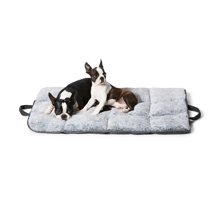  Pet comfortably lying on the Snooza Travel Mat in Charcoal, enjoying the calming plush surface.