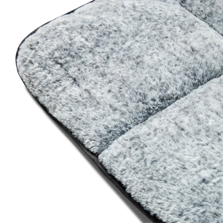 Close-up view of the deep-piled faux fur and contemporary storm grey exterior of the Snooza Travel Mat.